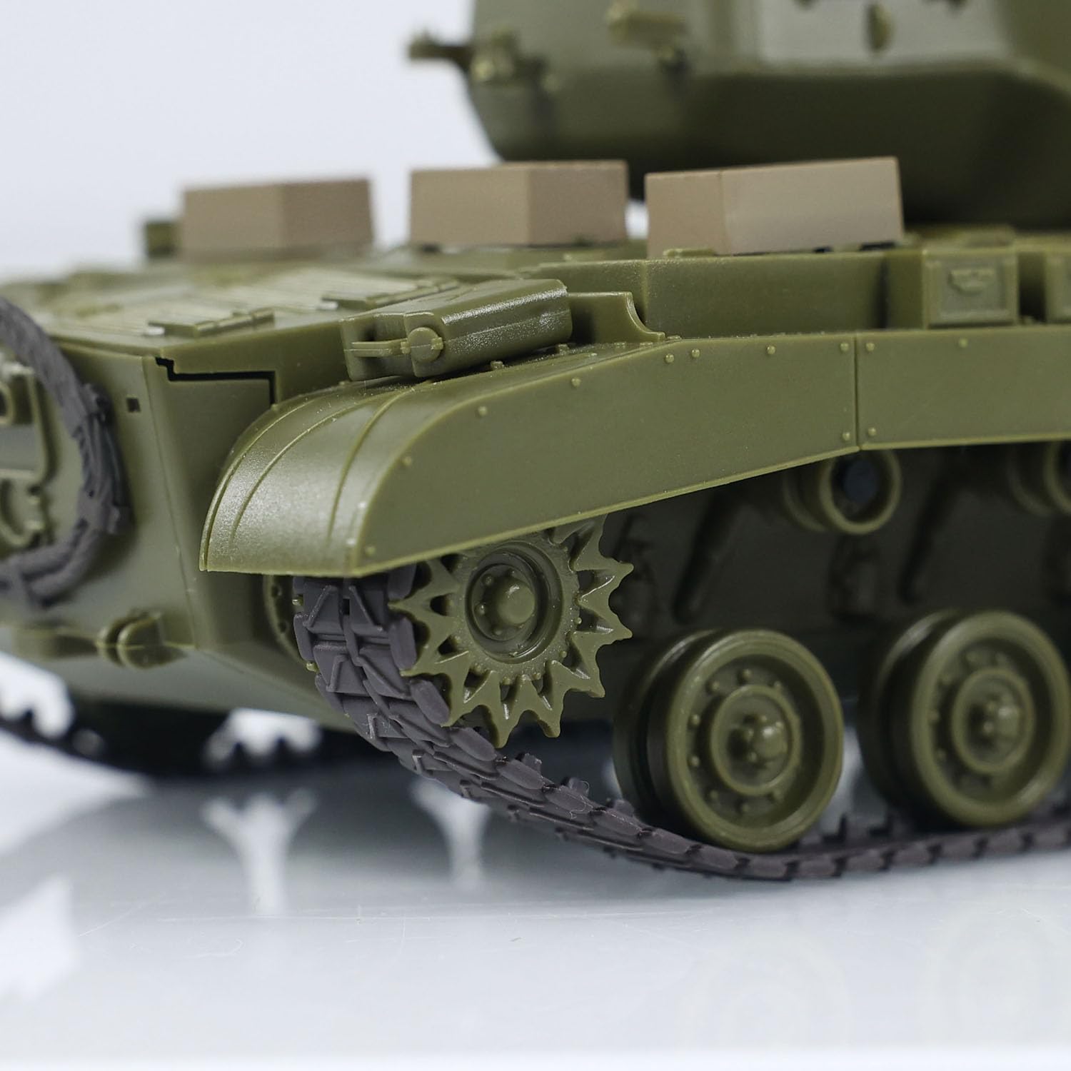 Close-up of a green toy tank on a reflective surface with a blurred background
